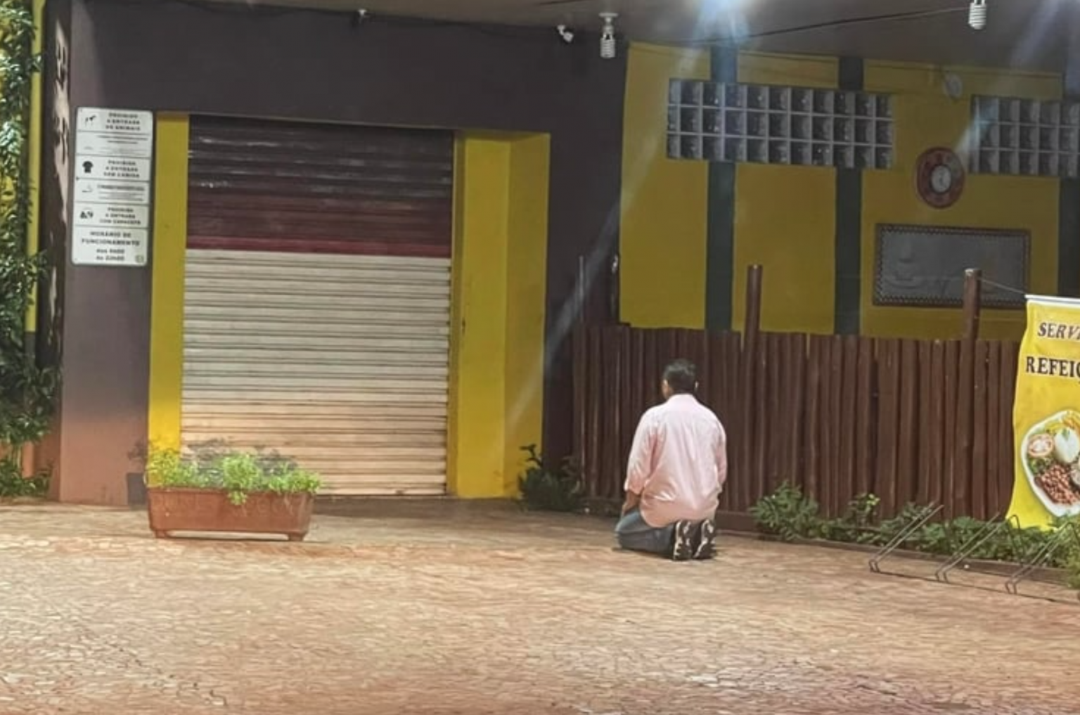 Proprietário faz orações em frente a padaria em crise