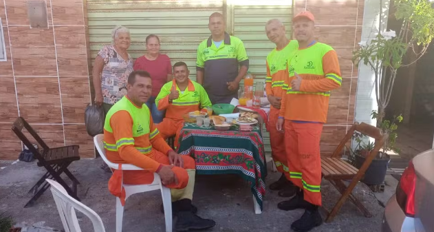 Moradoras preparam café da manhã natalino para garis que recolhem o lixo na rua onde moram, em Maceió